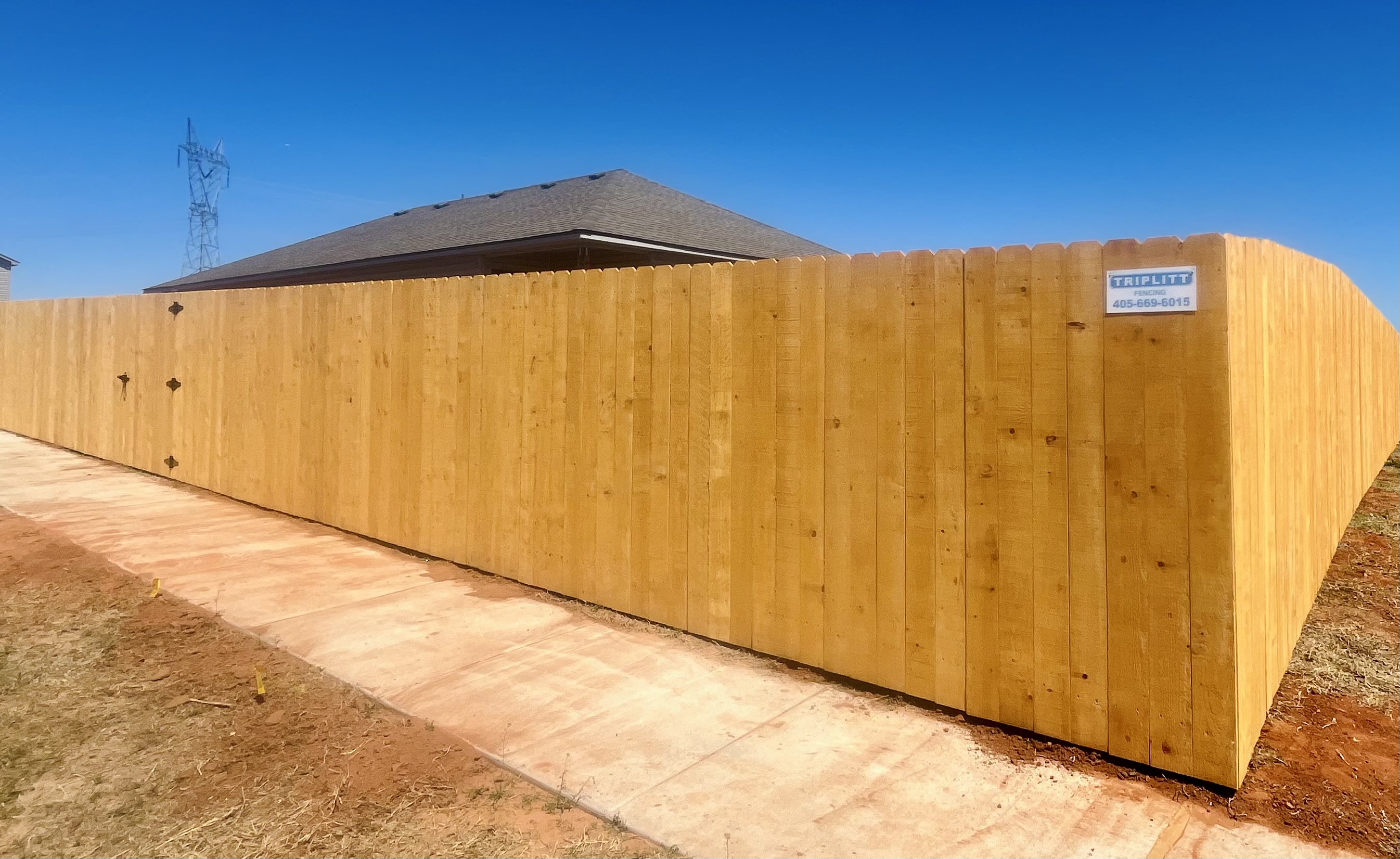 Happy customers and a beautiful Pre-stained Douglas Fir wood fence finalized in Yukon