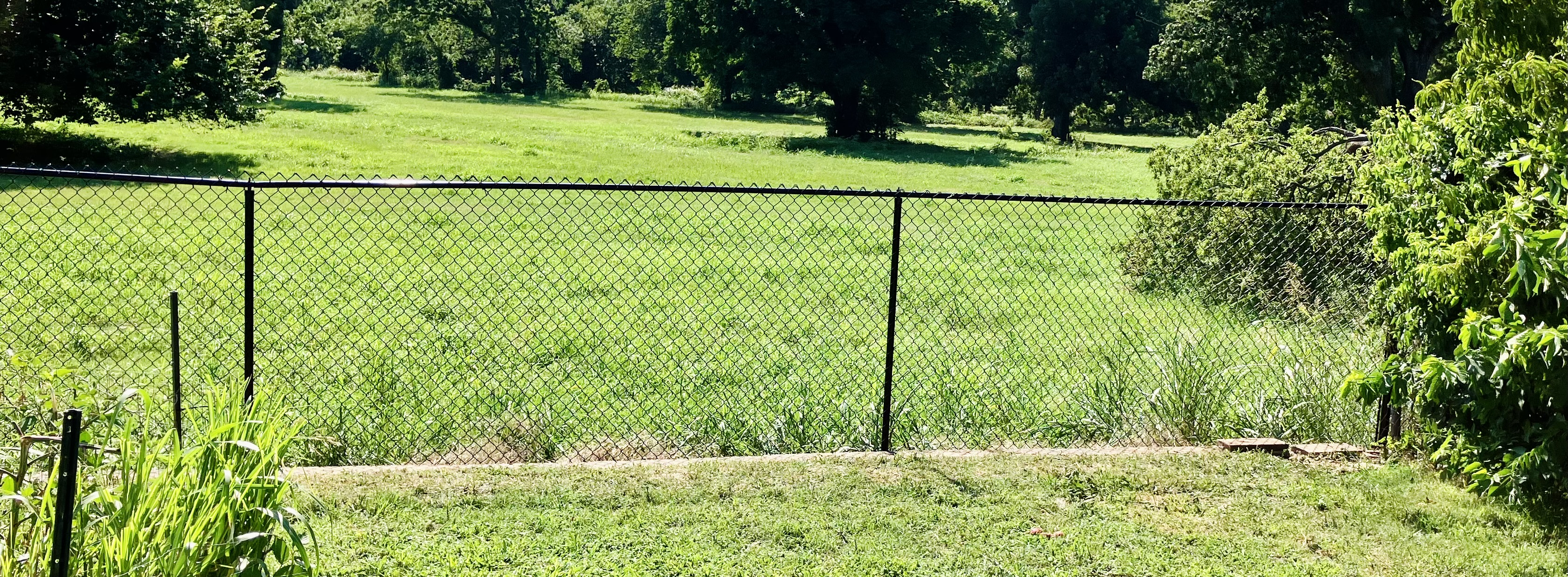 The perfect Cedar fence, complete with a very elegant black powder coated chainlink fence installed in Del City!